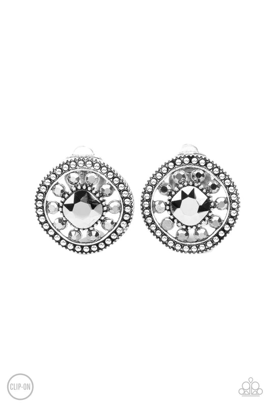 Featuring an oversized center, a hematite rhinestone encrusted flower blooms across the silver center of a studded frame for a sparkly finish. Earring attaches to a standard clip-on fitting.  Sold as one pair of clip-on earrings.