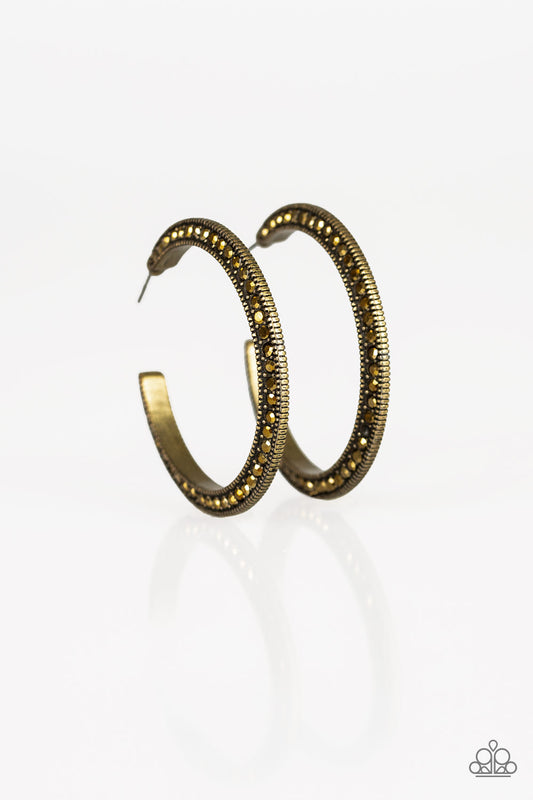 Both sides of a studded brass hoop are encrusted in golden aurum rhinestones for an edgy dazzle. Earring attaches to a standard post fitting. Hoop measures 1 1/2" in diameter.  Sold as one pair of hoop earrings.