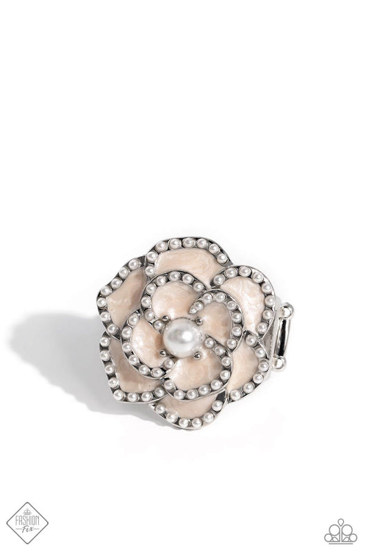 Layers of Tender Peach pearl-painted, heart-shaped petals curve around a white pearl center, creating an airy three-dimensional flower. Dainty white pearls dot along each curved petal adding refinement to the whimsical centerpiece atop the finger. Features a stretchy band for a flexible fit.  Sold as one individual ring.