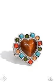 Bordering a gleaming brown cat's eye stone heart, a collection of circle and square-cut olive, Burnt Sienna, Doe, and turquoise stone and cat's eye beads alternate, creating a dazzling desert-inspired centerpiece atop the finger. Features a stretchy band for a flexible fit. As the stone elements in this piece are natural, some color variation is normal.  Sold as one individual ring.