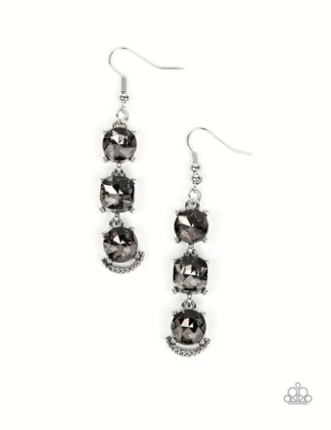 A trio of bold smokey rhinestones, set in pronged silver fittings, stack one above the other. The center rhinestone is almost imperceptibly square rather than round and the final rhinestone is accented with a gritty metallic crescent etched with ropelike texture, creating a ruggedly glamorous lure. Earring attaches to a standard fishhook fitting.  Sold as one pair of earrings.