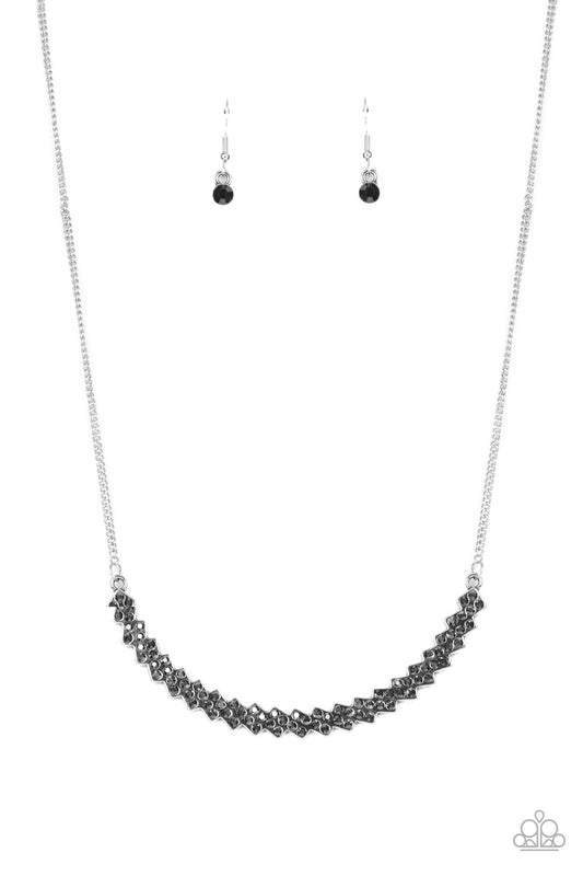 Dotted with smoky hematite rhinestones, dainty silver frames slant below the collar as they coalesce into a single curving centerpiece of dicey dazzle. Features an adjustable clasp closure.  Sold as one individual necklace. Includes one pair of matching earrings.