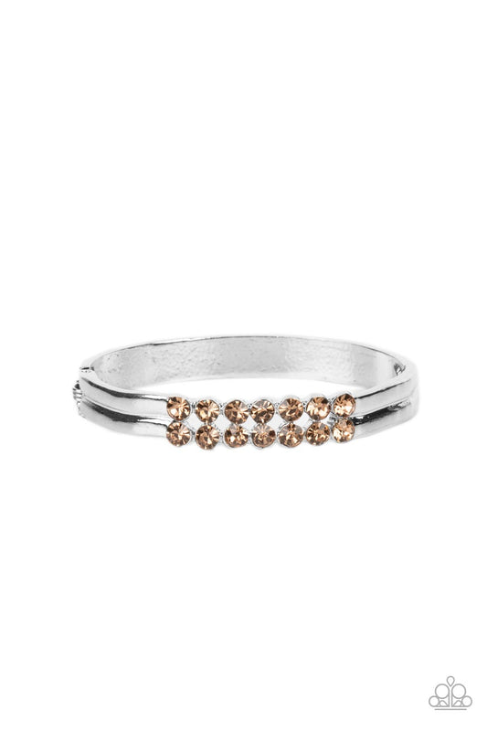 Two dramatic rows of golden topaz rhinestones stack atop the wrist, creating an elegantly layered cuff-like bangle. Features a hinged closure.  Sold as one individual bracelet.
