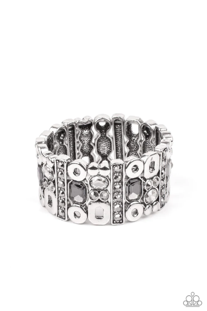 Infused with flat silver studs and geometric silver accents, a mismatched assortment of oval, round, and emerald style hematite and smoky rhinestones coalesce into edgy frames along a stretchy band for an intense sparkle around the wrist.  Sold as one individual bracelet.