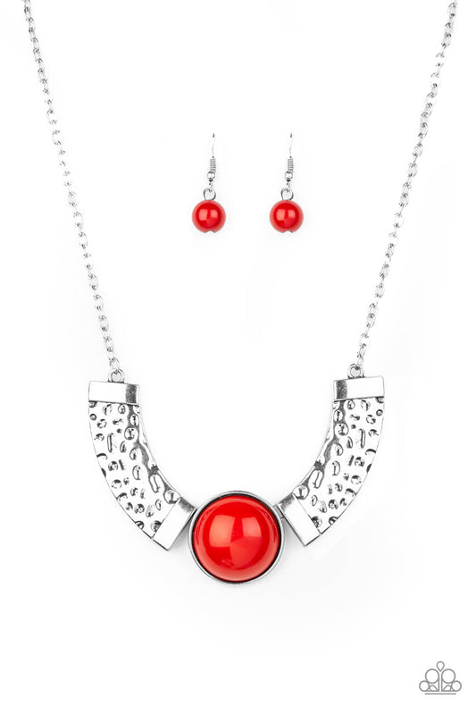 Dramatic silver plates connect with a shiny red beaded center, creating an indigenous collar-like pendant. The shiny silver plates are delicately hammered, adding a flashy metallic texture to the tribal inspired palette. Features an adjustable clasp closure.  Sold as one individual necklace. Includes one pair of matching earrings.