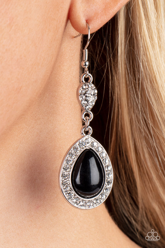 Bordered in glassy white rhinestones, an oversized black teardrop bead swings from the bottom of a dainty silver teardrop that is encrusted in glassy white rhinestones, resulting in a radiant lure. Earring attaches to a standard fishhook fitting.  Sold as one pair of earrings.