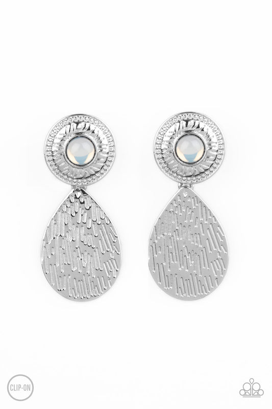 A hammered silver teardrop dangles from the bottom of an ornate silver disc that is dotted with a dreamy opal beaded center. Earring attaches to a standard clip-on fitting.  Sold as one pair of clip-on earrings.