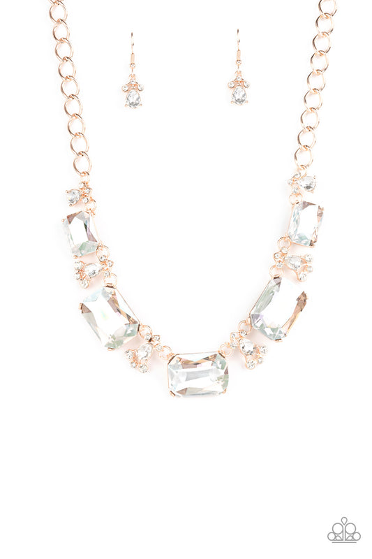 Encased in sleek rose gold fittings, an oversized collection of emerald cut white rhinestones link with rhinestone dotted teardrop rhinestone frames below the collar for a jaw-dropping display. Features an adjustable clasp closure.  Sold as one individual necklace. Includes one pair of matching earrings.