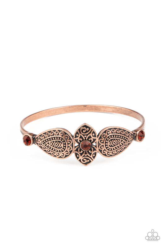 Embossed in decorative filigree, leafy copper frames connect into a whimsical centerpiece atop a copper bangle. Glittery rhinestones dot the ornate centerpiece, adding colorful sparkle to the dainty piece.  Sold as one individual bracelet.
