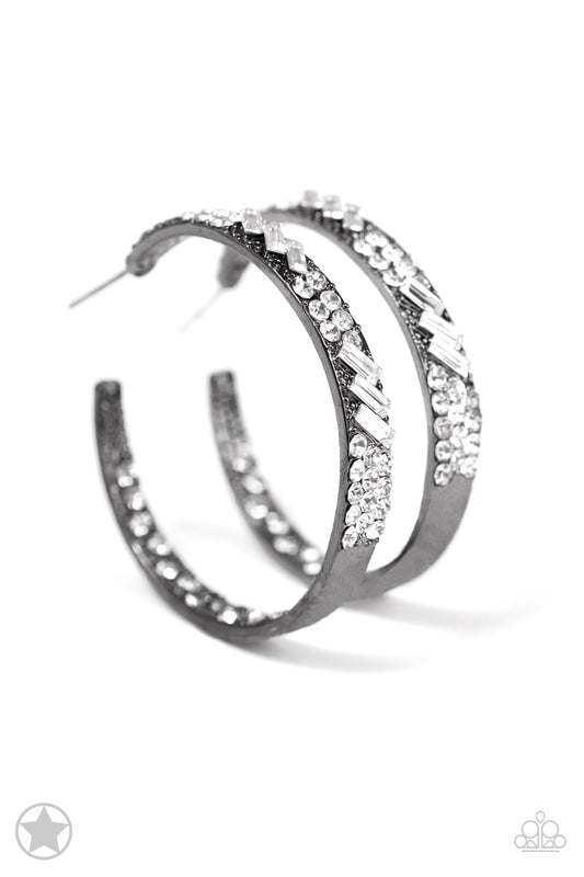 The front facing surface of a chunky gunmetal hoop is dipped in brilliantly sparkling hematite rhinestones while light-catching texture wraps around the back. The interior of the hoop features the opposite pattern, creating the illusion of a full hoop of blinding shimmer. Earring attaches to a standard post fitting. Hoop measures 1 3/4" in diameter.  Sold as one pair of hoop earrings.