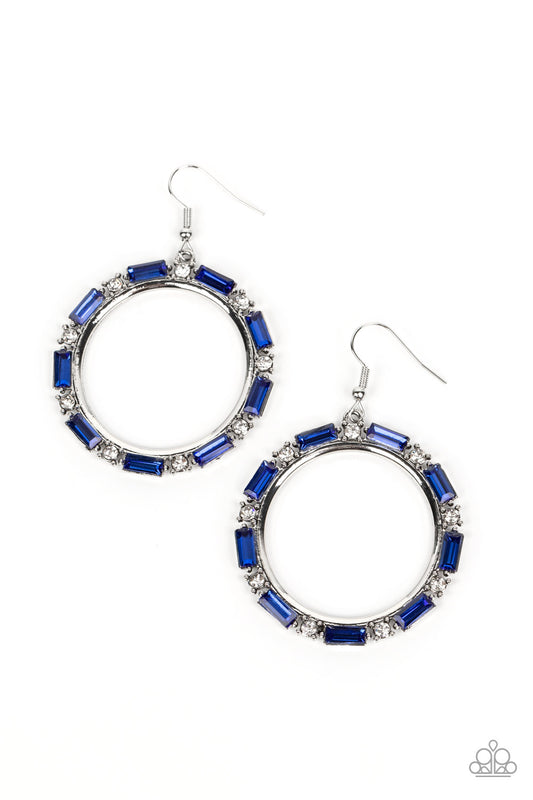 A glittery collection of round white and emerald cut blue rhinestones smolders along the outside rim of a shiny silver hoop, resulting in an edgy centerpiece. Earring attaches to a standard fishhook fitting.  Sold as one pair of earrings.