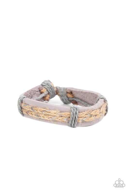 Glimmering metallic thread is braided with natural twine and laced to the top of a lavender leather band creating a rustic homespun style around the wrist. Features an adjustable sliding knot closure.  Sold as one individual bracelet.
