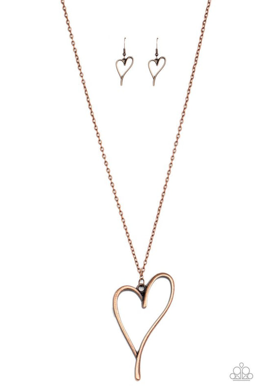 An asymmetrical copper heart charm swings from the bottom of a lengthened copper chain, creating a whimsical pendant. Features an adjustable clasp closure.  Sold as one individual necklace. Includes one pair of matching earrings.