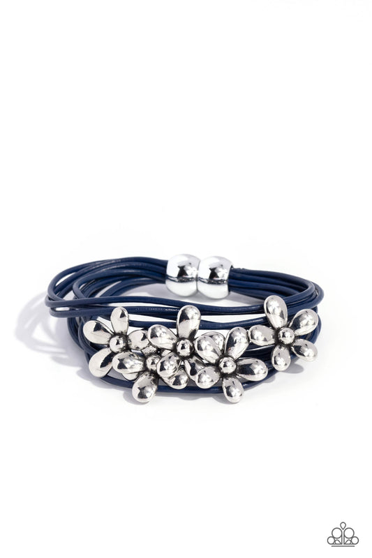 Shiny silver flowers glide along leathery blue cords, clustering into a shimmery floral statement piece at the center of the wrist. Features a magnetic closure.  Sold as one individual bracelet.