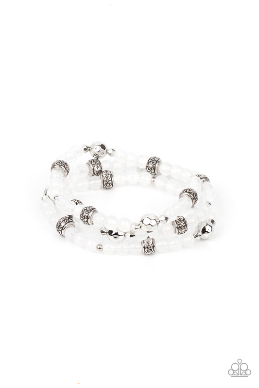 A dainty collection of faceted silver beads, floral embossed accents, and glassy white beads are threaded along stretchy bands around the wrist for a colorfully seasonal look.

Sold as one set of three bracelets.
