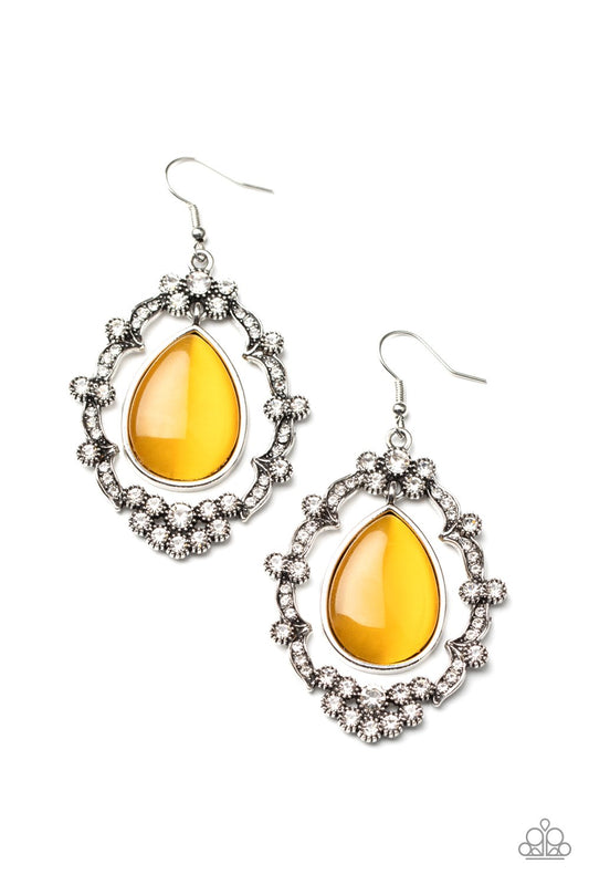 A teardrop yellow cat's eye stone swings from the top of an ornately white rhinestone encrusted frame, creating an icy lure. Earring attaches to a standard fishhook fitting.

Sold as one pair of earrings.