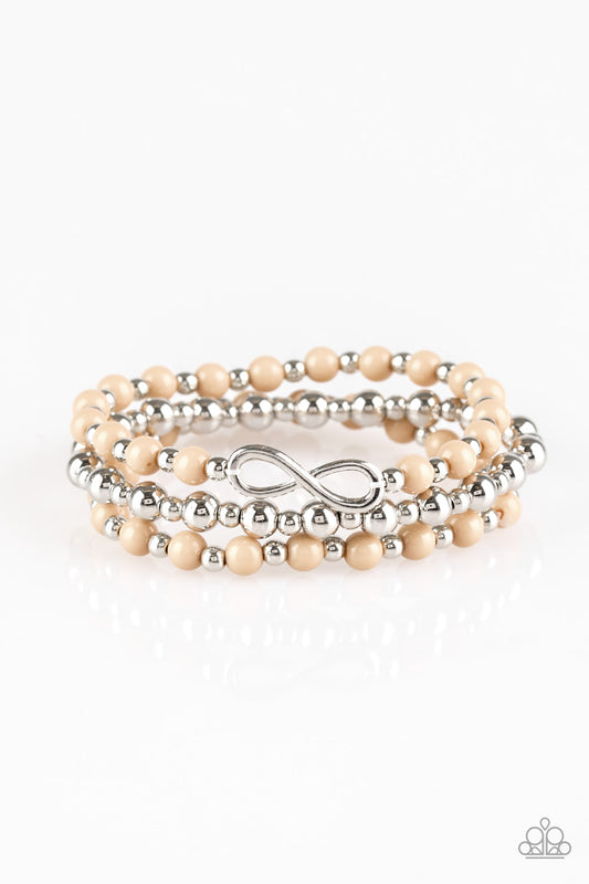 Neutral brown and shiny silver beads are threaded along stretchy bands, creating colorful layers around the wrist. A dainty silver infinity charm adorns one strand for a whimsical finish.

Sold as one set of three bracelets.