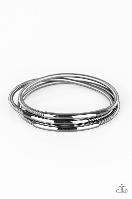 A collection of gunmetal accents slide along stretchy spring-like wires for a sleek industrial look.

Sold as one set of three bracelets.