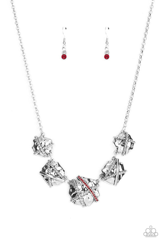 Hammered in a rustic finish, an asymmetrical collection of beveled silver frames are adorned with textured and smooth bands of silver. Gradually increasing in size, the centermost frame features a row of fiery red rhinestones for a splash of glitz below the collar. Features an adjustable clasp closure.  Sold as one individual necklace. Includes one pair of matching earrings.