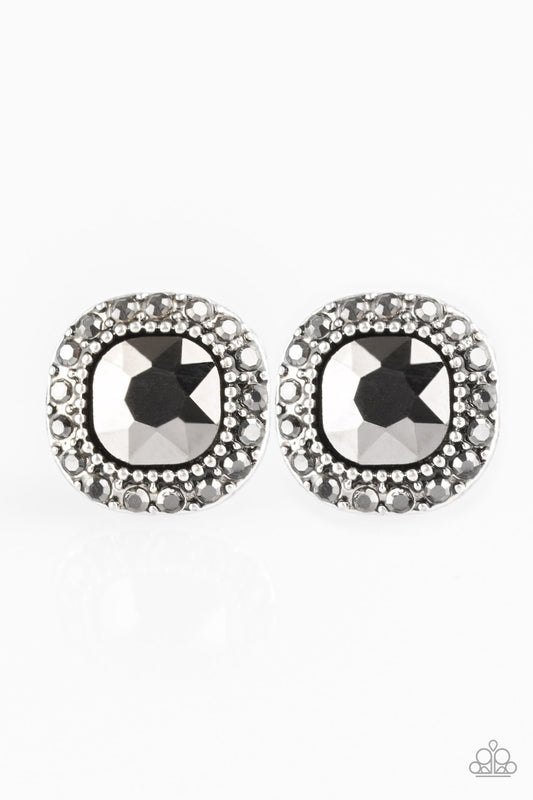 An oversized hematite gem is pressed into the center of a studded silver frame radiating with glittery hematite rhinestones for a timeless look. Earring attaches to a standard post fitting.  Sold as one pair of post earrings.