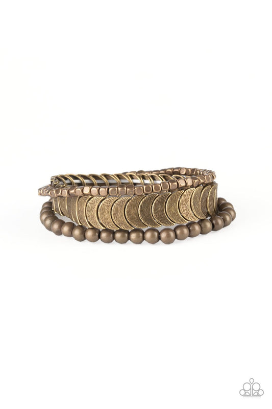 Featuring round, cube, and half-moon shapes, mismatched brass beads are threaded along stretchy bands, creating trendy mixed metallic layers around the wrist.

Sold as one set of three bracelets.