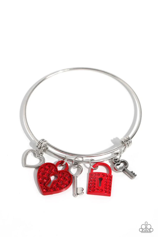 Featuring red rhinestones, a mismatched collection of silver keys, a red key lock, a silver heart, and red heart lock charms glides along a silver bar fitting at the center of the wrist for a youthful flair.

Sold as one individual bracelet