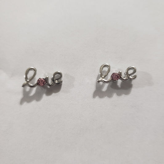 Kid's silver earrings with the word LOVE and a pink rhinestone in the letter "O"
