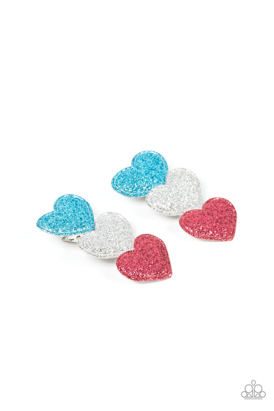 Dusted in sparkles, a puffy trio of blue, silver, and pink heart frames neatly stacks into a flirtatious centerpiece. Features a standard hair clip on the back.  Sold as one pair of hair clips.