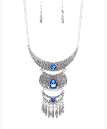 Embossed in studded, geometric, and paisley filigree-like patterns, three mismatched silver half moon plates dramatically link below the collar. Featuring an iridescent UV shimmer, an oversized collection of square, teardrop, and round rhinestones embellish the decorative silver frames, while a silver beaded fringe swings from the lowermost plate for a noisemaking finish. Features an adjustable clasp closure.  Sold as one individual necklace. Includes one pair of matching earrings.