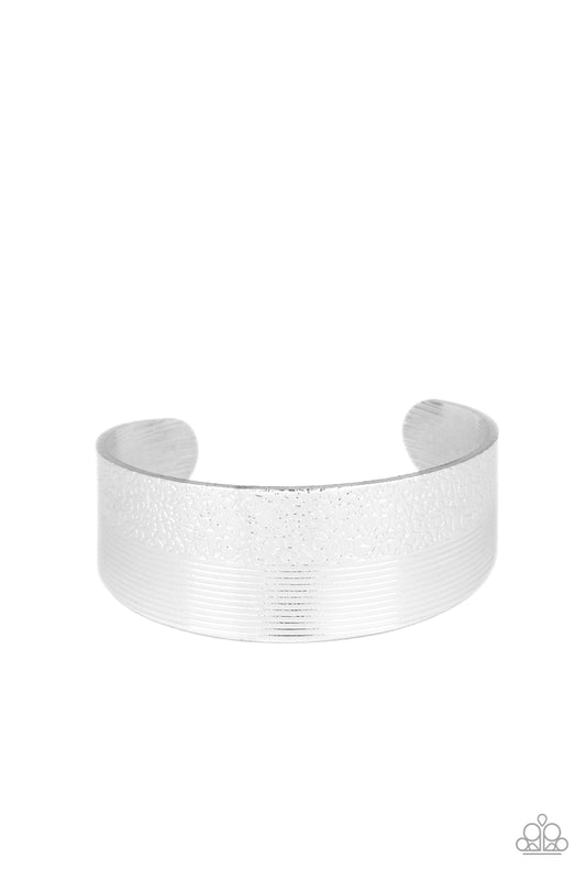 One half of a thick silver cuff is engraved in stacked linear lines while the other half is hammered in a row of tactile textures, creating a collision of texture around the wrist.  Sold as one individual bracelet.