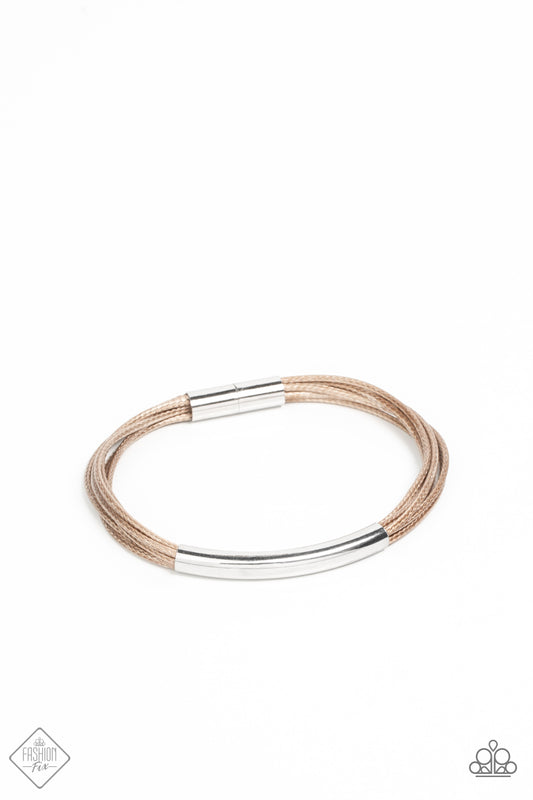 A contemporary curved silver cylinder slides along smooth strands of natural brown cording as they wrap around the wrist. The cording is capped in sleek silver fittings for a modern polished finish. Features a magnetic closure.  Sold as one individual bracelet.