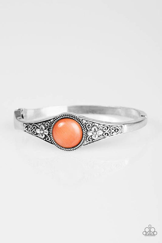 A glassy orange moonstone is pressed into the center of a shimmery silver bangle embossed in a whimsical floral pattern for a seasonal look. Features a hinged clasp.  Sold as one individual bracelet.