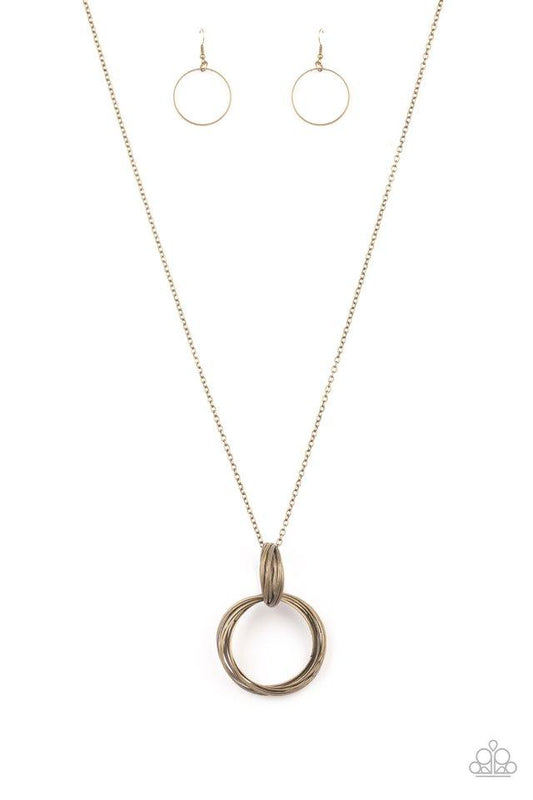A collection of large and small antiqued brass rings interlock into a bold pendant at the bottom of a lengthened brass chain. Features an adjustable clasp closure.

Sold as one individual necklace. Includes one pair of matching earrings.