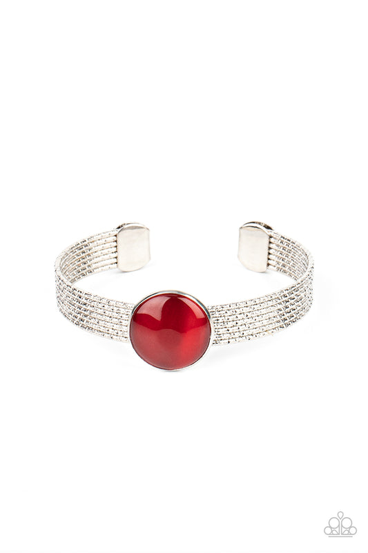 A glassy red cat's eye stone frame sits atop a layered silver cuff that is etched in shimmery textures, creating a glittery centerpiece.  Sold as one individual bracelet.