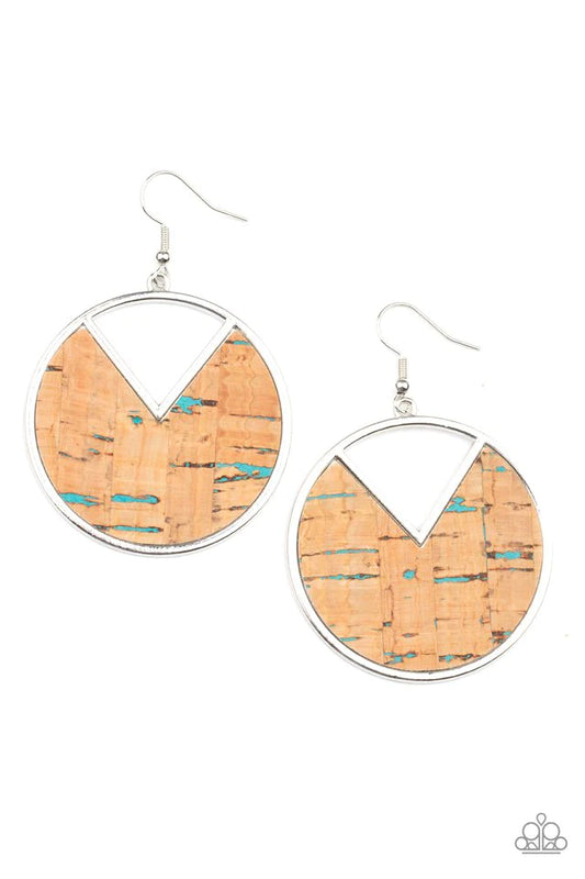 Featuring hints of blue accents, an earthy piece of cork is placed into the center of a circular hoop. A triangular slice is removed from the cork, creating an edgy airy finish. Earring attaches to a standard fishhook fitting.  Sold as one pair of earrings.