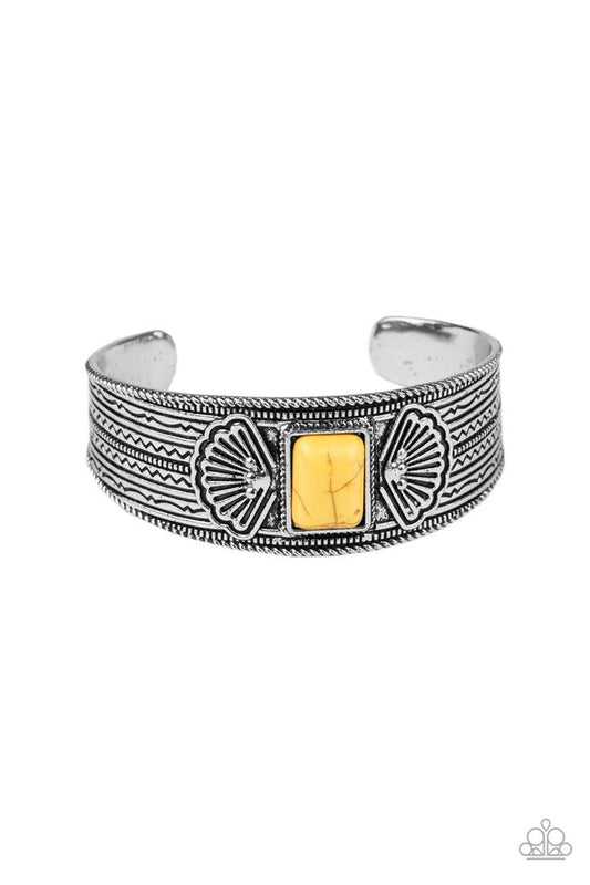 A rectangular yellow stone is pressed into the center of a decorative silver cuff that is stamped in shell-like and tribal inspired patterns for a seasonal flair.  Sold as one individual bracelet.