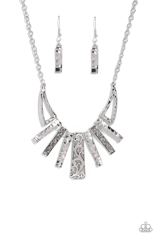 Streaming from a glittery silver chain, warped silver bars with a hammered sheen alternate between warped bars featuring an embossed paisley pattern for a garden statement. Abstract triangles, in the same hammered sheen border the abstract bar display for additional attention-drawing detail down the neckline. Features an adjustable clasp closure.  Sold as one individual necklace. Includes one pair of matching earrings.