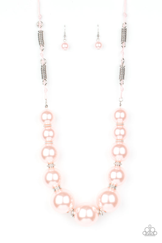 Separated by stacks of smooth and decorative silver rings, a collection of dramatically oversized pink pearls are delicately hand-strung along an invisible wire that attaches to knotted strands of pink cording for a classically handcrafted look. Features an adjustable clasp closure.  Sold as one individual necklace. Includes one pair of matching earrings.