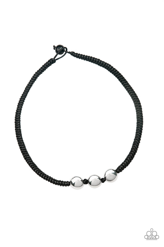 Three shiny silver beads are knotted in place along a black braided cord below the collar for an urban look. Features a button loop closure.  Sold as one individual necklace.