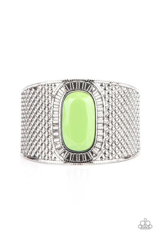 An oversized faceted green bead is pressed into the center of a thick silver cuff embossed in diamond-like textures, creating a bold tribal inspired centerpiece around the wrist.  Sold as one individual bracelet.