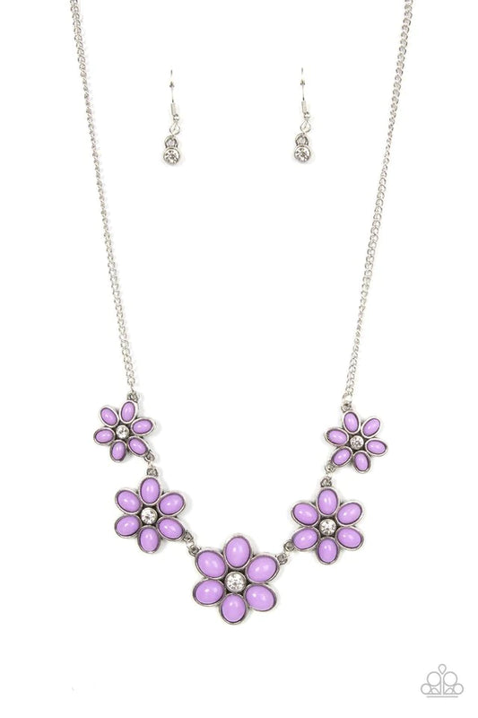 Dotted with dainty white rhinestone centers, a flirtatious assortment of purple beaded flowers gradually increase in size as they link below the collar for a playful pop of color. Features an adjustable clasp closure.  Sold as one individual necklace. Includes one pair of matching earrings.