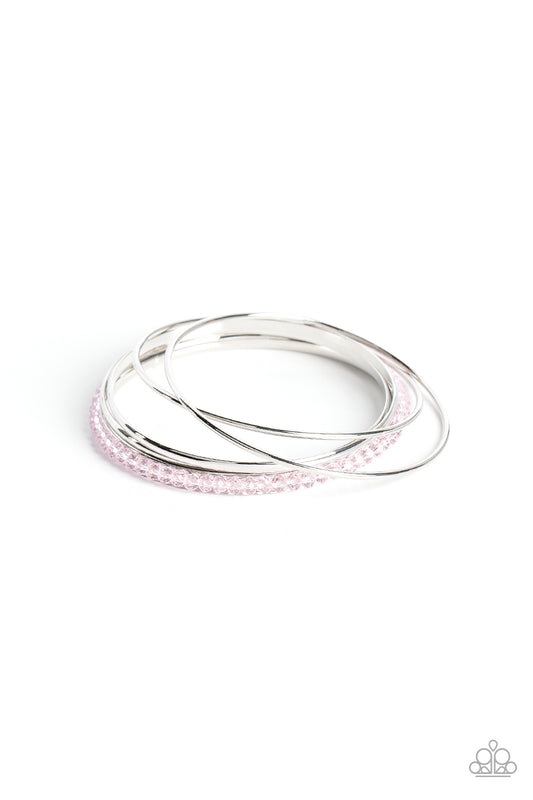 Pairs of dainty and flat silver bangles join a silver bangle adorned in Gossamer Pink crystal-like beads around the wrist, resulting in a stackable shimmer.  Sold as one set of five bracelets.