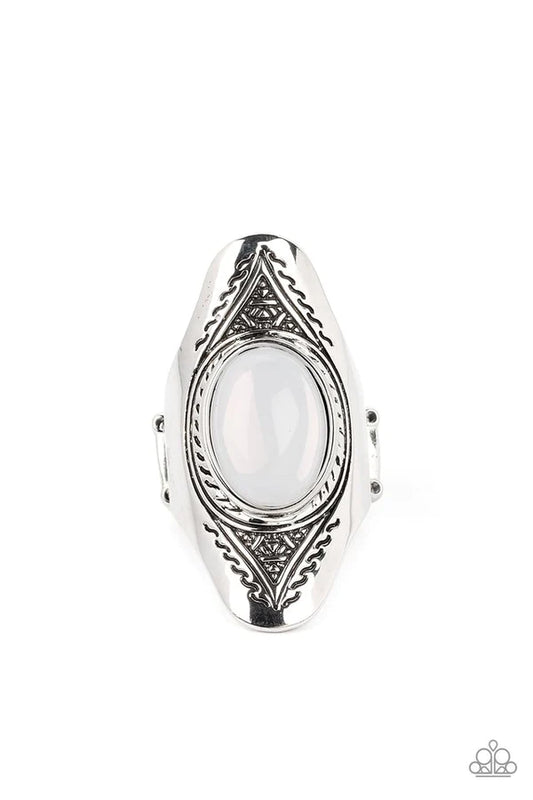 An oversized, glassy, opal bead is pressed into the center of a dramatically elongated silver frame. Triangular patterns are etched into the frame as it folds around the finger, resulting in an ethereal pop of color atop the finger. Features a stretchy band for a flexible fit.  Sold as one individual ring.