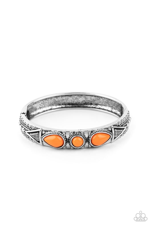 Studded in tribal inspired designs, the top of an antiqued silver cuff-like bangle is embellished with shiny Amberglow beads for a colorful look. Features a hinged closure.  Sold as one individual bracelet.