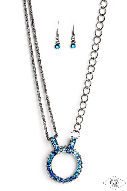A collision of mismatched gunmetal chains gives way to a studded gunmetal pendant that has been encrusted in glittery blue UV rhinestones. The result is a gritty, industrial design with endless attitude. Features an adjustable clasp closure.  Sold as one individual necklace.  Includes one pair of matching earrings.