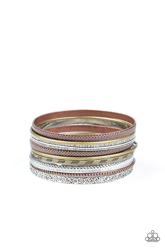 Featuring smooth, studded, hammered, and textured finishes, a mismatched collection of copper, brass, and silver bangles stack across the wrist for a seasonal look.  Sold as one set of nine bracelets.