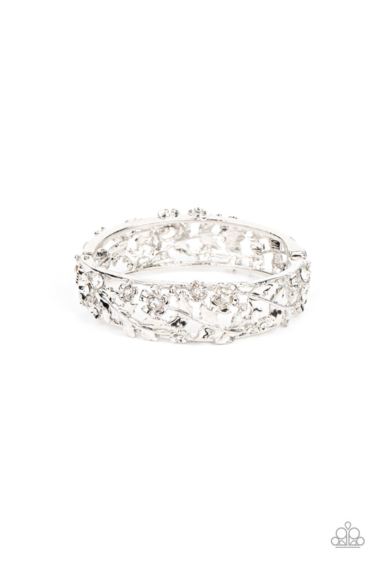 Dotted with dainty white rhinestone centers, flowering leafy silver vines bloom into two oversized silver frames that delicately hinge into a versatile bangle-like bracelet. Features a hinged closure.  Sold as one individual bracelet.