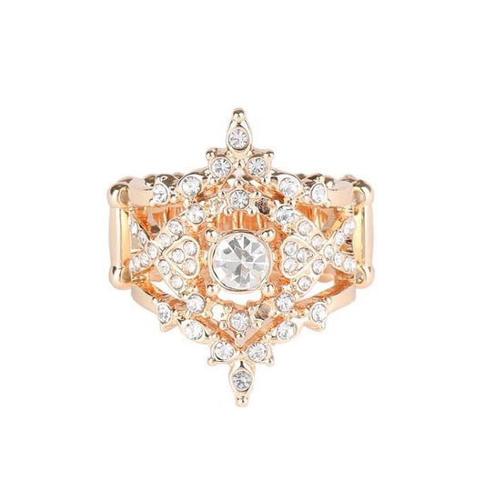 Dotted in glassy white rhinestones, dainty gold bands and flirty heart-shaped gold frames weave around a timeless white rhinestone center, creating a regally layered centerpiece atop the finger. Features a stretchy band for a flexible fit.  Sold as one individual bracelet.