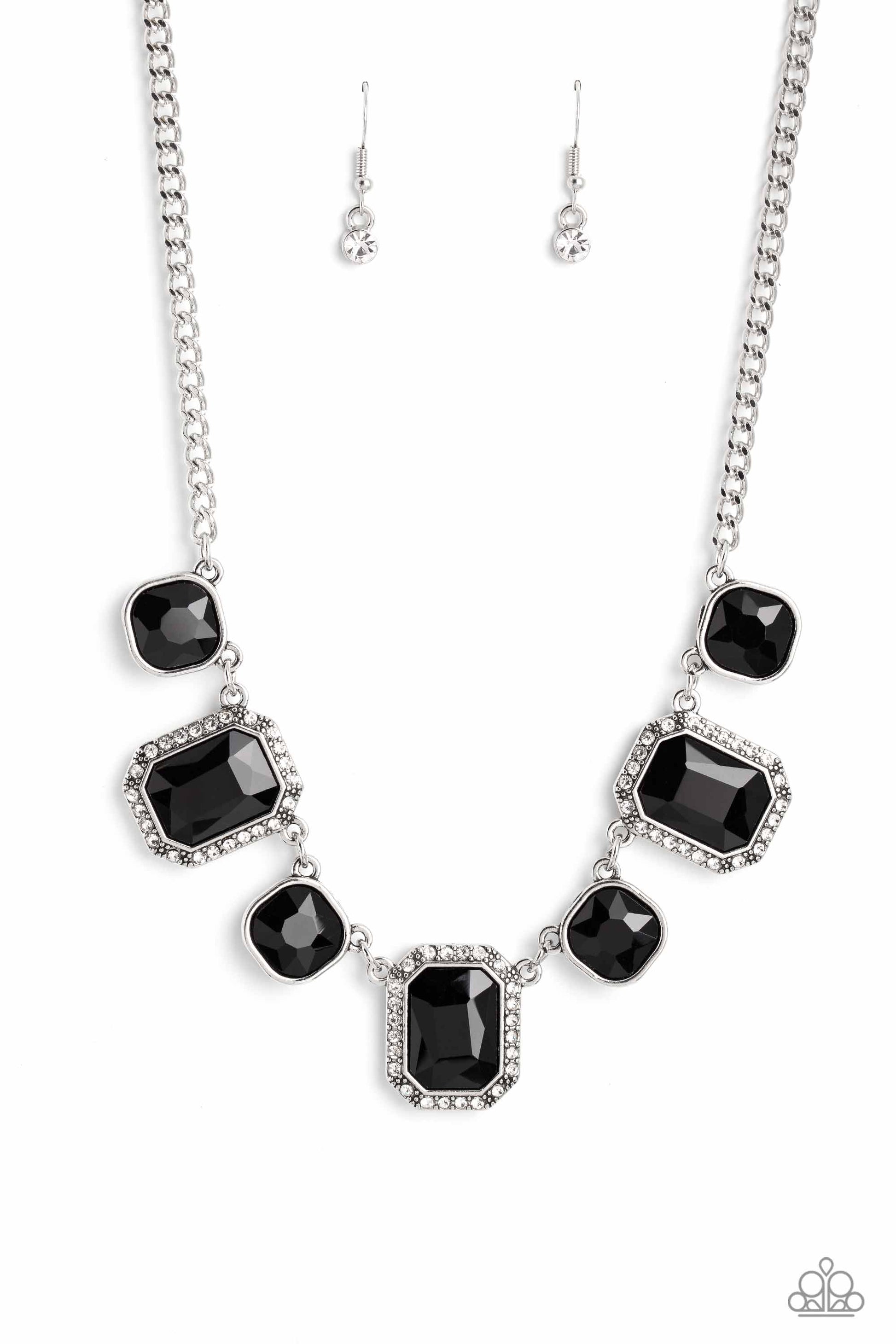 Dazzling gems, in both round and emerald-cuts, fall along the collar in an alternating pattern. Each gem is splashed in a dauntless, jet black hue amplifying its impact, while the emerald-cut gems showcase some glittery bling with a border of tiny white rhinestones. Features an adjustable clasp closure.  Sold as one individual necklace. Includes one pair of matching earrings.