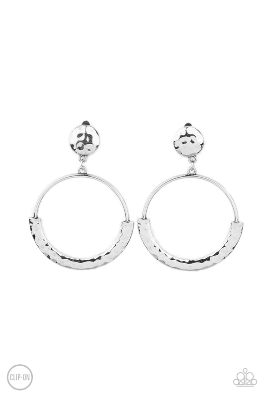 The bottom of an antiqued silver hoop is covered with a bowing hammered frame at the bottom of a hammered silver disc, creating a rustic lure. Earring attaches to a standard clip-on fitting.  Sold as one pair of clip-on earrings.